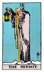 The Hermit standing with a staff in one hand and a lantern in the other
